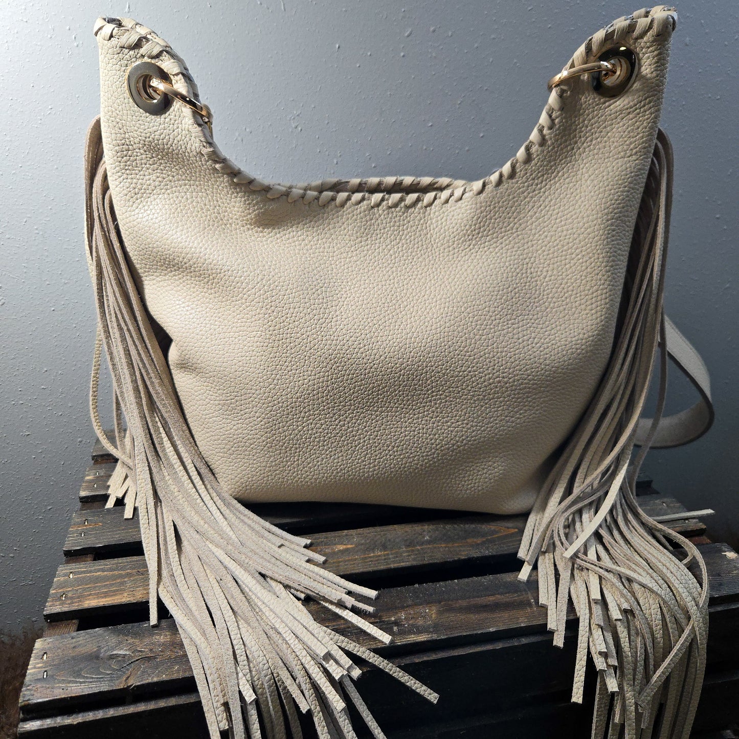 Back view of Uptown Cowgirl brown and cream western fringe bag in cream pebbled leather with long fringe sides