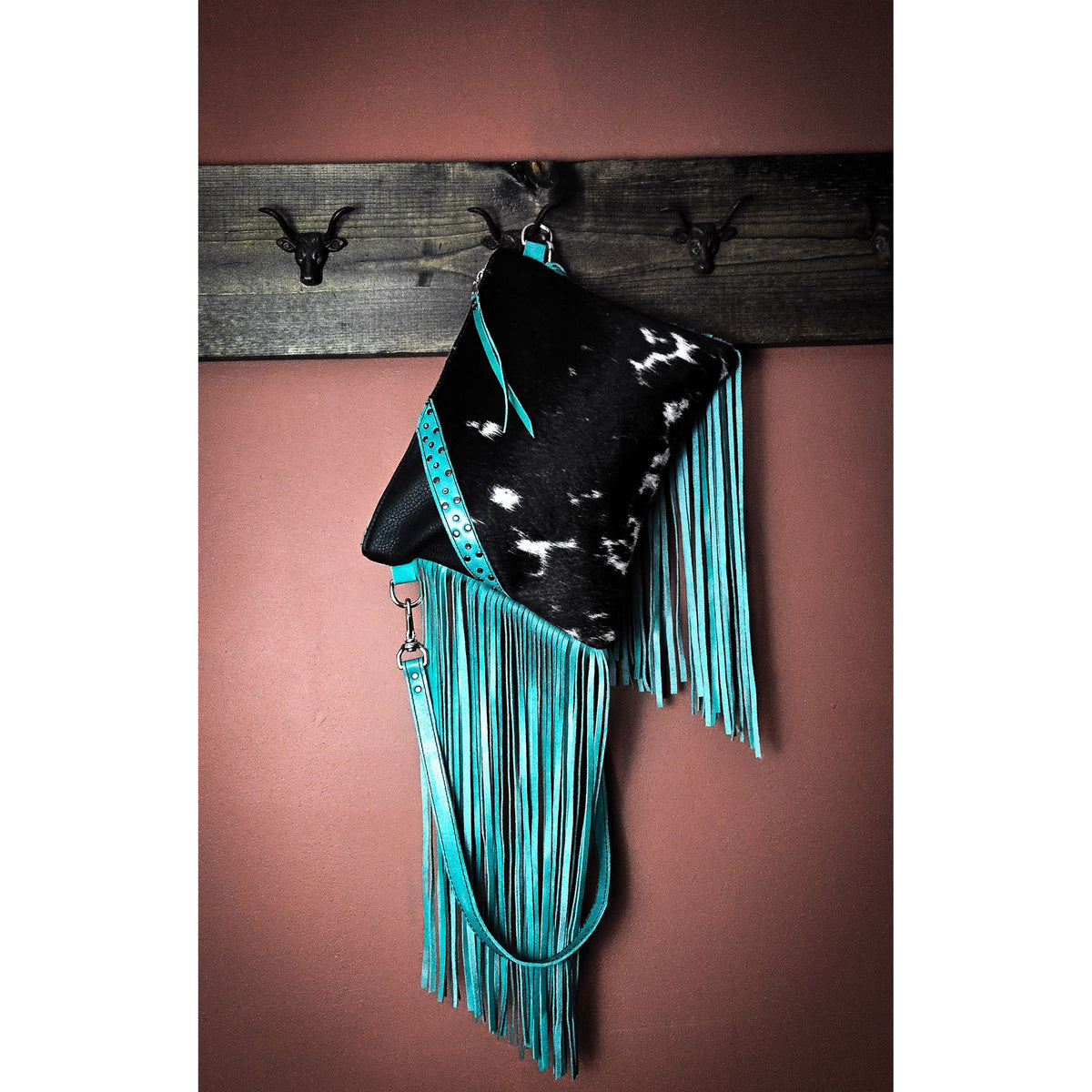 Hair-on-hide front pocket with long hand-cut leather fringe