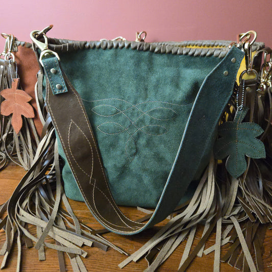 Handcrafted moss suede bag with stitched leaf design and leather-laced top