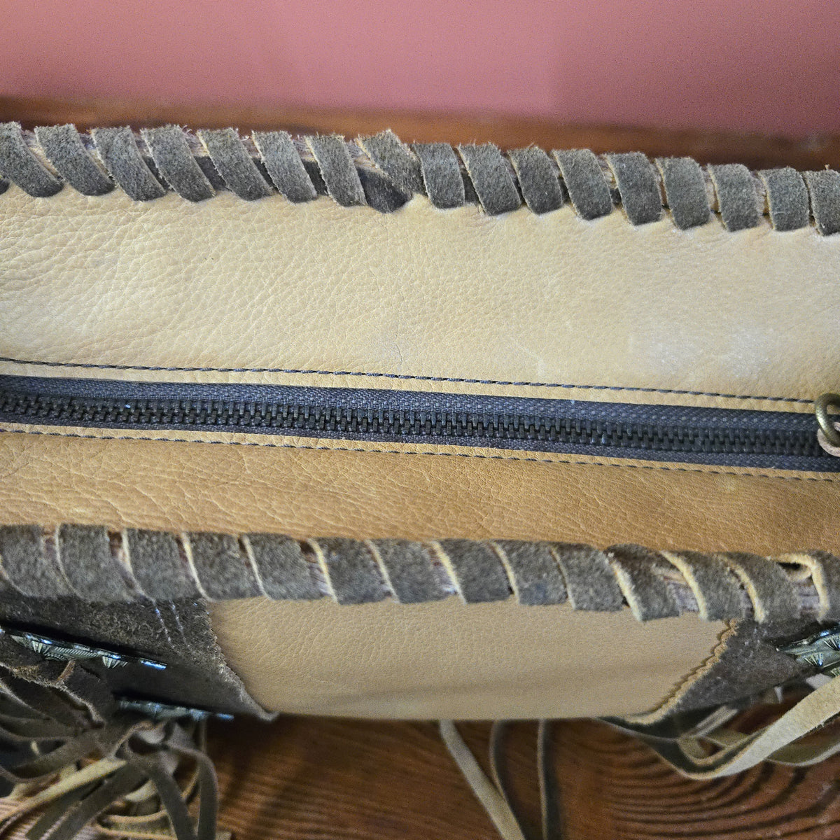 Wheat leather bag with hand-laced edge and top zipper closure