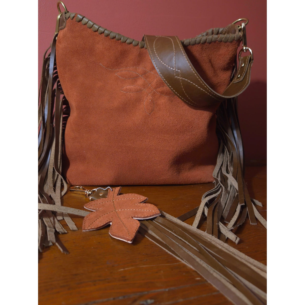 Rust suede fringe shoulder bag with gunslinger-stitched strap and matching tassel