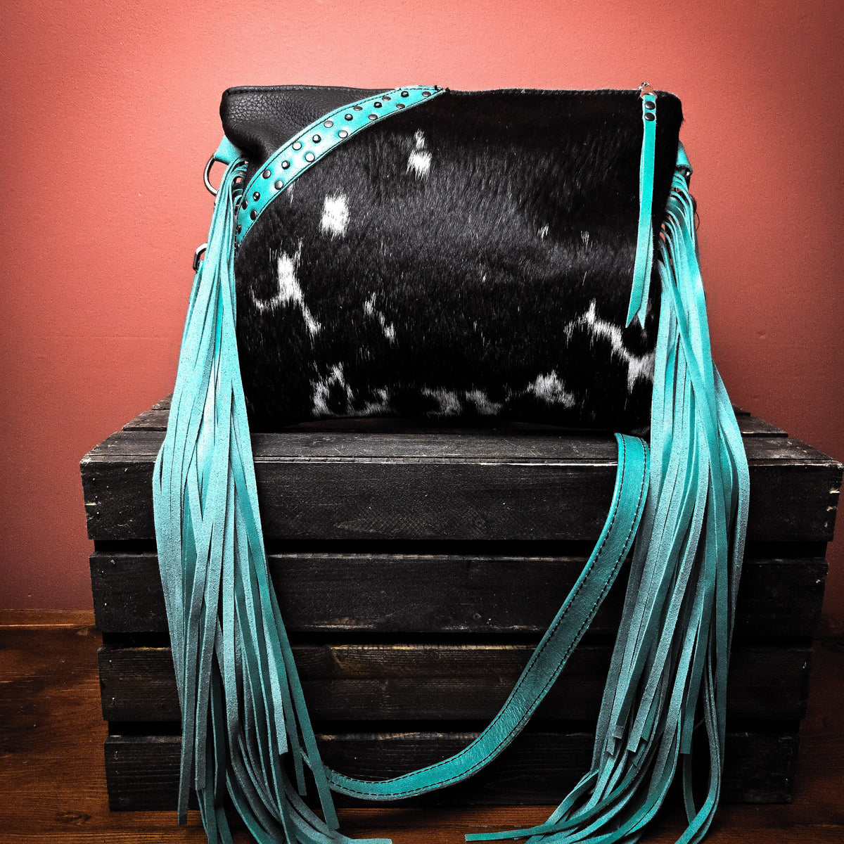 Turquoise leather shoulder bag with hair-on-hide front pocket and hand-cut fringe