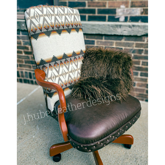 Western office chair with chocolate leather seat, hair-on-hide back, PENDLETON® wool, concho accents, and copper nail heads with brick wall slightly blurred out and watermark